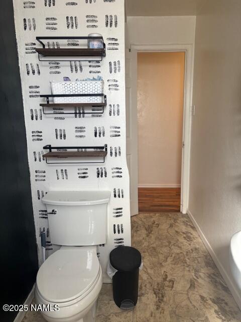 bathroom featuring toilet and baseboards