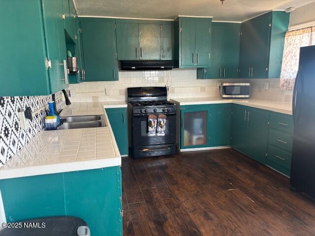 kitchen featuring backsplash, dark wood finished floors, under cabinet range hood, and black appliances