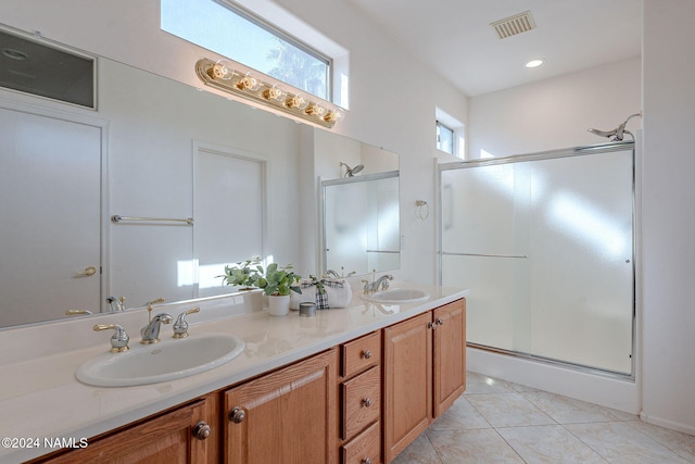 bathroom with tile patterned flooring, vanity, and a shower with door