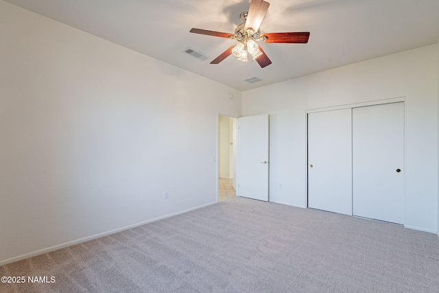 unfurnished bedroom featuring light carpet, ceiling fan, and a closet