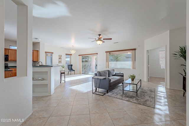 living room with ceiling fan, sink, and light tile patterned floors