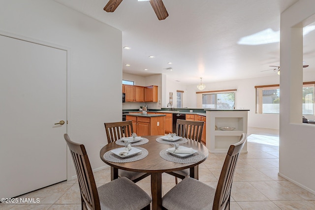 dining space with light tile patterned floors, sink, and ceiling fan