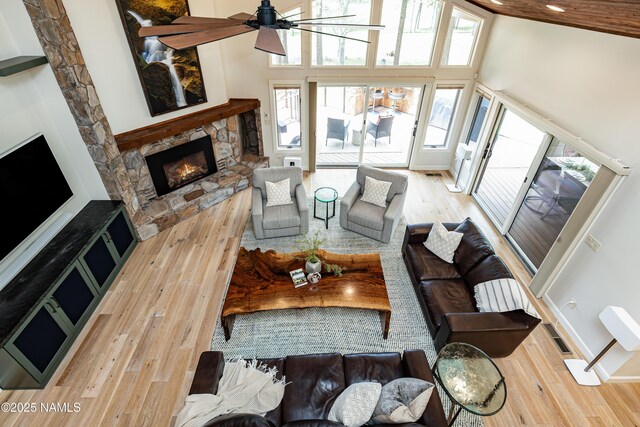 1451 N Mariposa Rd, Flagstaff, AZ 86004 - living room featuring wood-type flooring, a towering ceiling, a ceiling fan, a fireplace, and baseboards