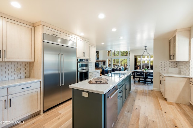 1451 N Mariposa Rd, Flagstaff, AZ 86004 - kitchen with appliances with stainless steel finishes, a kitchen island, recessed lighting, backsplash, and light wood finished floors