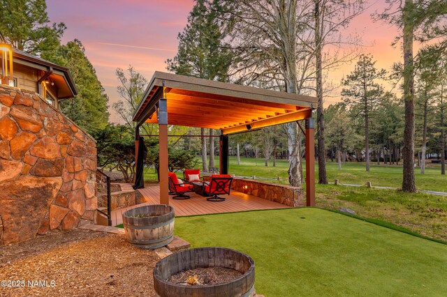 1451 N Mariposa Rd, Flagstaff, AZ 86004 - yard at dusk with an outdoor fire pit, a wooden deck, a yard, and an area to practice putting