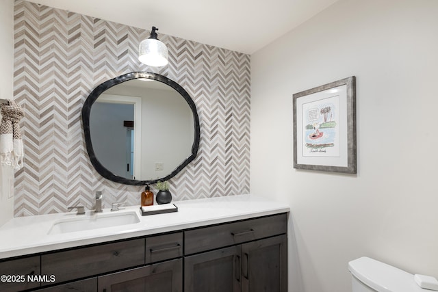 1451 N Mariposa Rd, Flagstaff, AZ 86004 - bathroom with an accent wall, toilet, wallpapered walls, vanity, and decorative backsplash
