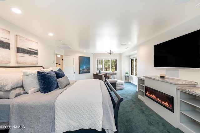 1451 N Mariposa Rd, Flagstaff, AZ 86004 - bedroom with a glass covered fireplace, dark carpet, and recessed lighting