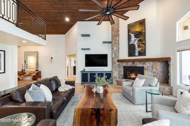 1451 N Mariposa Rd, Flagstaff, AZ 86004 - living room featuring wooden ceiling, a high ceiling, ceiling fan, wood finished floors, and a stone fireplace