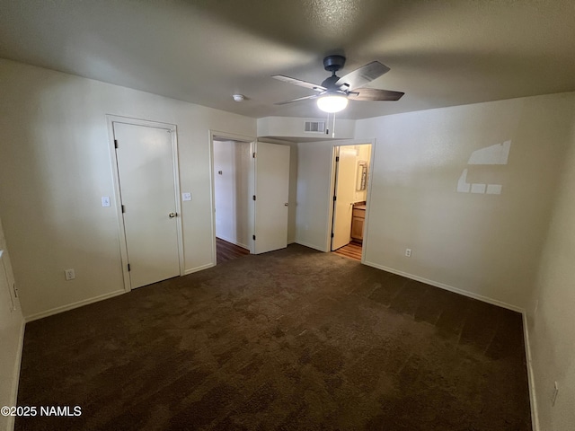 1185 W University Dr Unit 15-222, Flagstaff, AZ 86001 - unfurnished bedroom featuring dark colored carpet, connected bathroom, and a ceiling fan