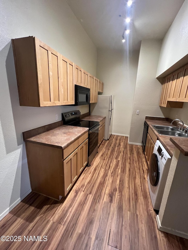 1185 W University Dr Unit 15-222, Flagstaff, AZ 86001 - kitchen with stainless steel electric range oven, black microwave, washer / clothes dryer, freestanding refrigerator, and wood finished floors