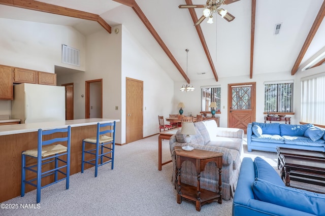 living room featuring light colored carpet, beam ceiling, high vaulted ceiling, ceiling fan with notable chandelier, and visible vents