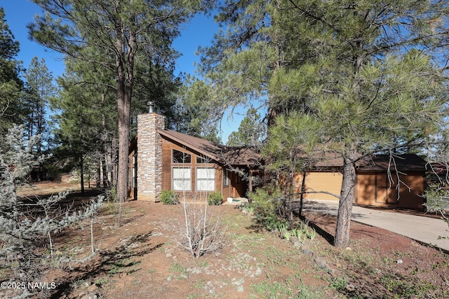 view of front facade featuring driveway and a chimney