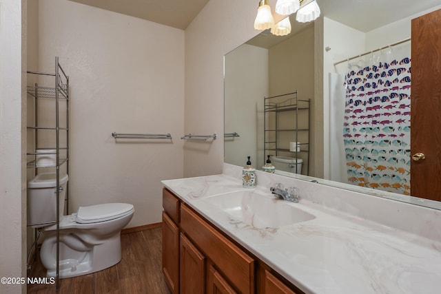 bathroom with wood finished floors, vanity, baseboards, toilet, and a chandelier