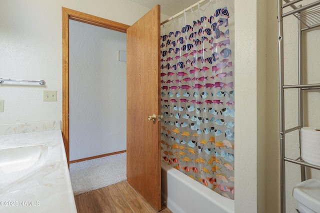 bathroom featuring vanity, shower / bathtub combination with curtain, and wood finished floors