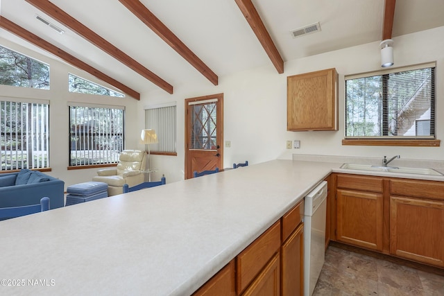kitchen featuring lofted ceiling with beams, a sink, light countertops, open floor plan, and visible vents