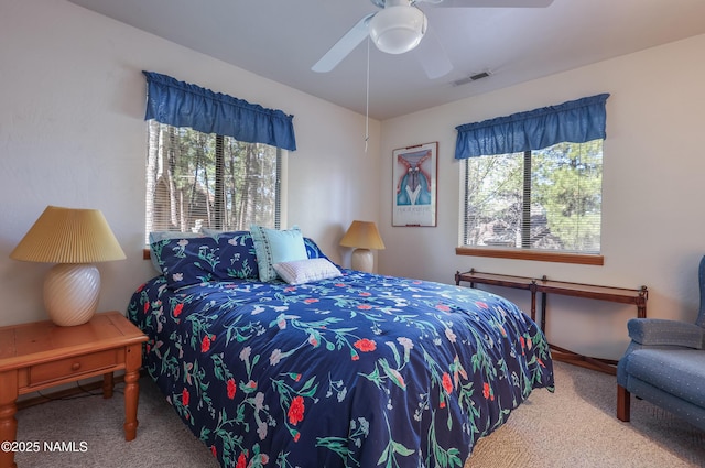 bedroom with ceiling fan, visible vents, and carpet