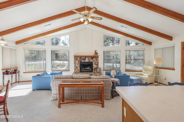 living area with a healthy amount of sunlight, beamed ceiling, a fireplace, and visible vents