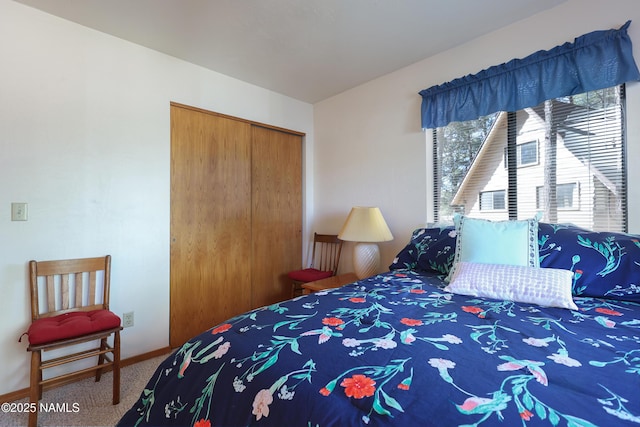 carpeted bedroom with baseboards and a closet