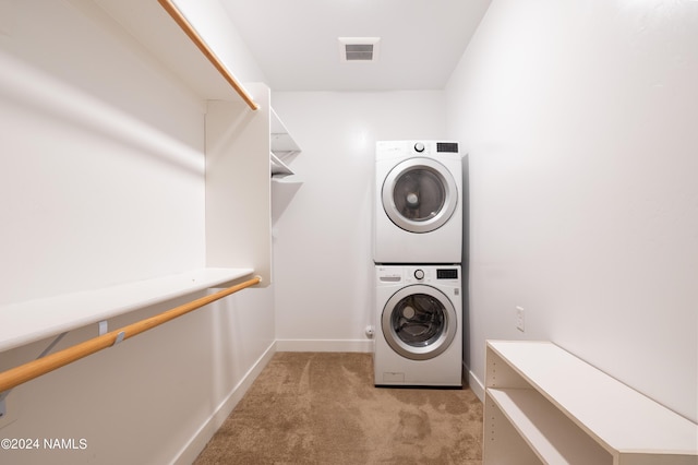 washroom featuring light colored carpet and stacked washer and clothes dryer