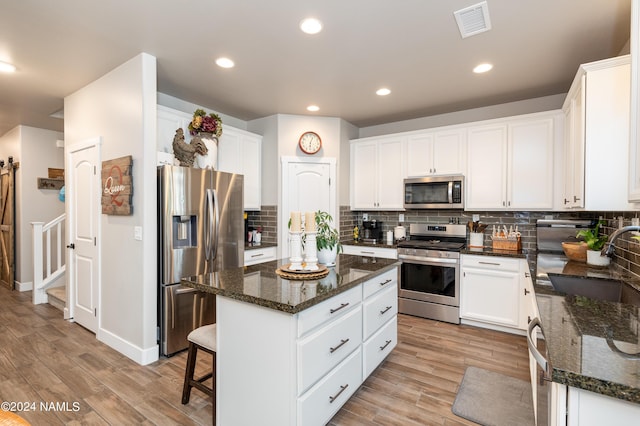 kitchen with a kitchen island, white cabinetry, appliances with stainless steel finishes, and sink