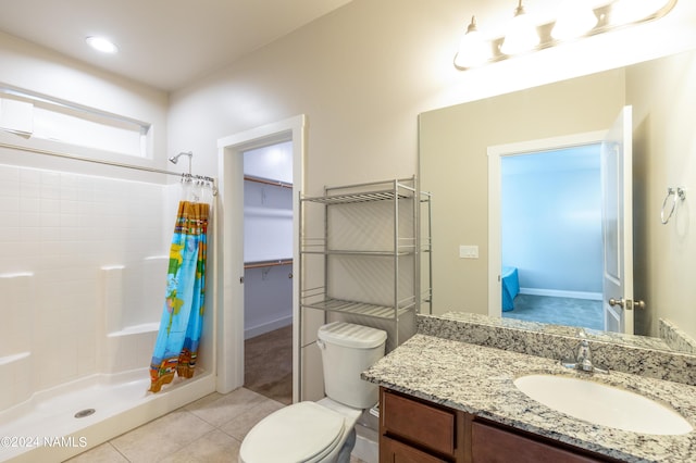 bathroom featuring walk in shower, vanity, toilet, and tile patterned flooring