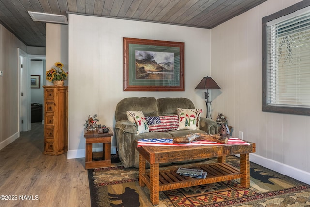 living area featuring visible vents, wood finished floors, baseboards, and wooden ceiling