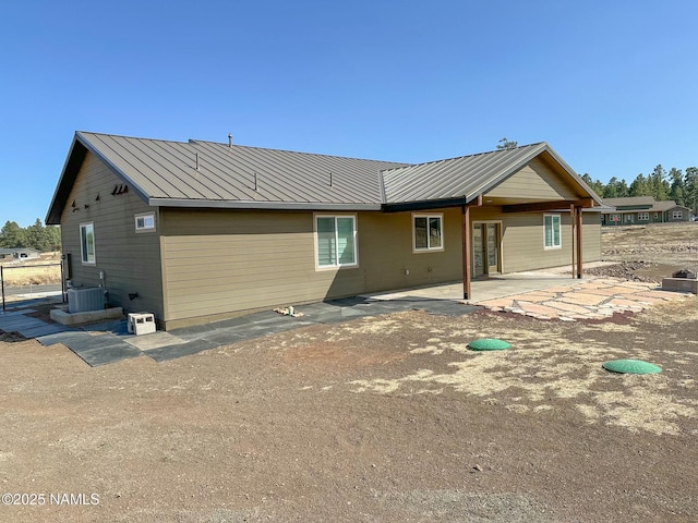 rear view of property featuring a patio, metal roof, and central air condition unit