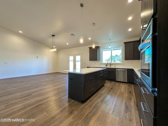 kitchen featuring stainless steel appliances, a center island, french doors, and dark wood-type flooring