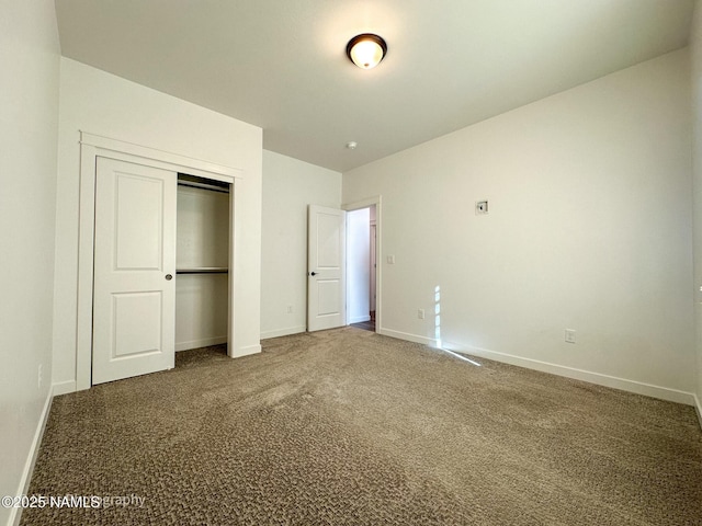 unfurnished bedroom featuring carpet, baseboards, and a closet