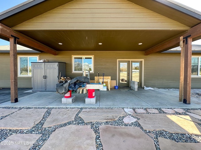 view of patio with a shed and an outbuilding