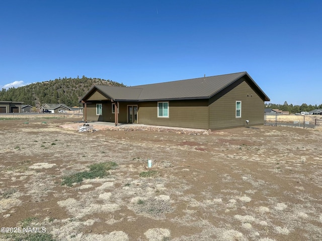view of front of house featuring metal roof and fence