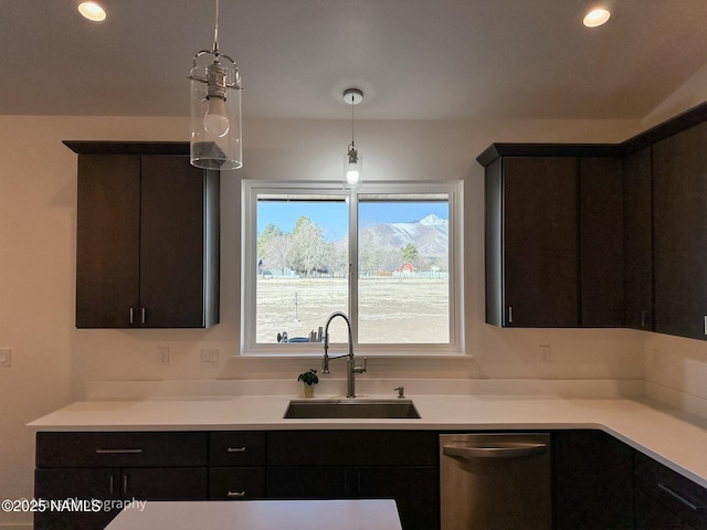 kitchen featuring stainless steel dishwasher, light countertops, a sink, and recessed lighting