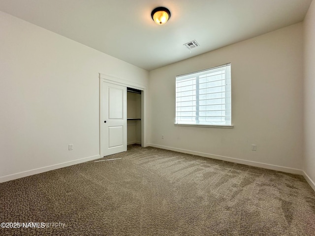 unfurnished bedroom featuring a closet, baseboards, visible vents, and carpet flooring