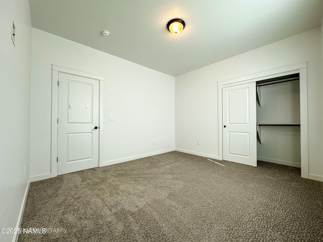 unfurnished bedroom with a closet, carpet flooring, and baseboards