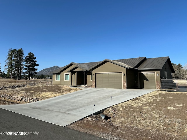 ranch-style house with metal roof, a garage, brick siding, fence, and concrete driveway