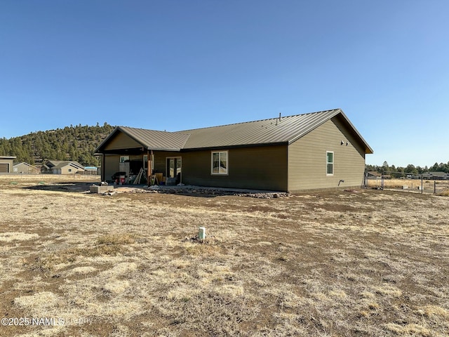 view of front facade with fence and metal roof