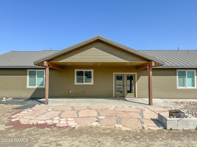 rear view of house featuring metal roof, a standing seam roof, french doors, and a patio area