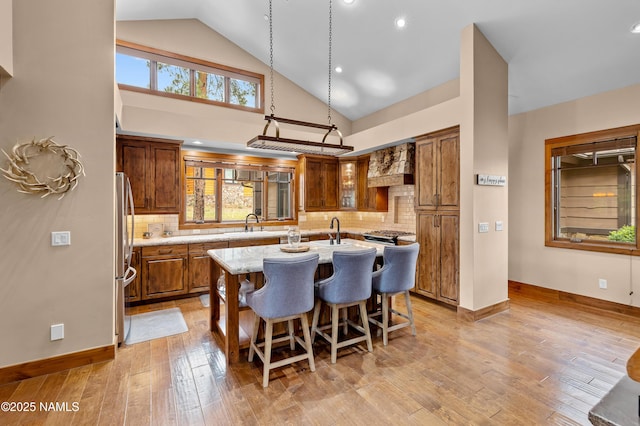 2047 E Del Rae Dr Unit 163, Flagstaff, AZ 86005 - kitchen with a center island with sink, custom exhaust hood, light wood finished floors, decorative backsplash, and recessed lighting