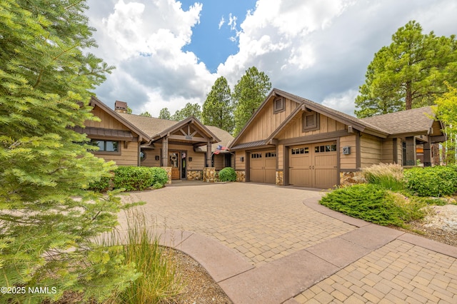 2047 E Del Rae Dr Unit 163, Flagstaff, AZ 86005 - view of front of property featuring board and batten siding, a garage, stone siding, decorative driveway, and a chimney