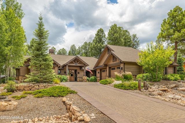 2047 E Del Rae Dr Unit 163, Flagstaff, AZ 86005 - view of front of property featuring decorative driveway, stone siding, an attached garage, and a shingled roof