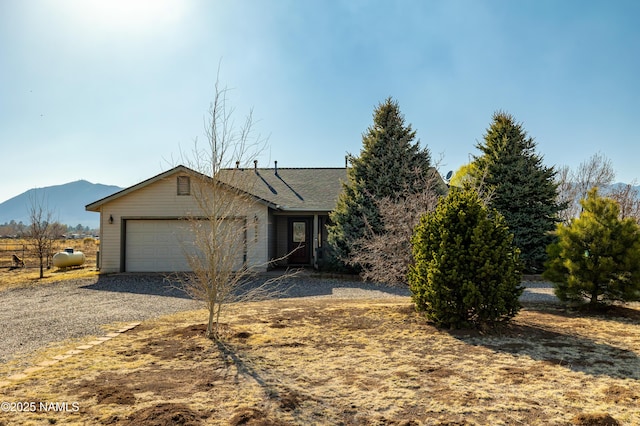 ranch-style home featuring a mountain view, a garage, and driveway