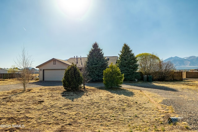 view of front of home featuring a mountain view, a garage, and fence