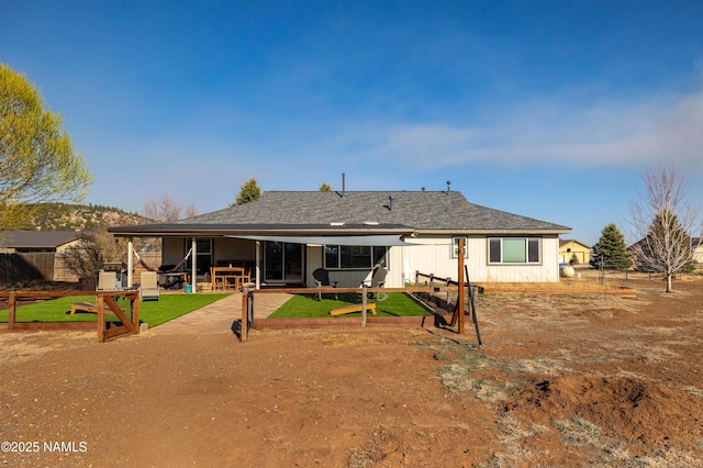 back of house with roof with shingles, a yard, a patio area, and fence