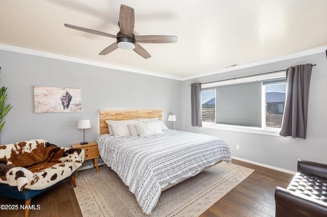 bedroom featuring ceiling fan, ornamental molding, visible vents, wood finished floors, and baseboards