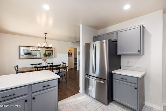 kitchen with an inviting chandelier, gray cabinetry, and stainless steel appliances