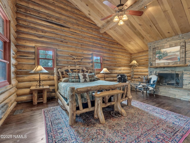 bedroom with ceiling fan, dark hardwood / wood-style flooring, a stone fireplace, log walls, and high vaulted ceiling