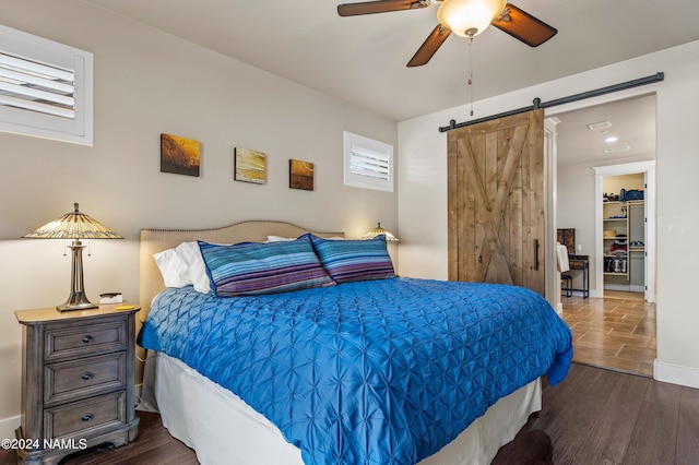 bedroom featuring ceiling fan and a barn door