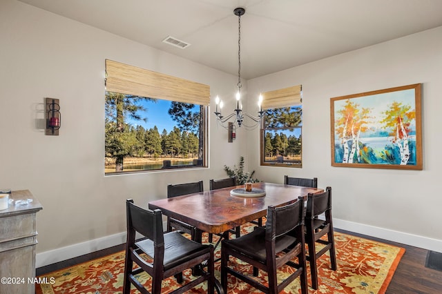 dining room with dark hardwood / wood-style flooring and a chandelier