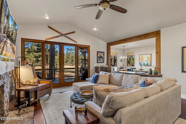 living room featuring ceiling fan with notable chandelier, french doors, hardwood / wood-style floors, and lofted ceiling