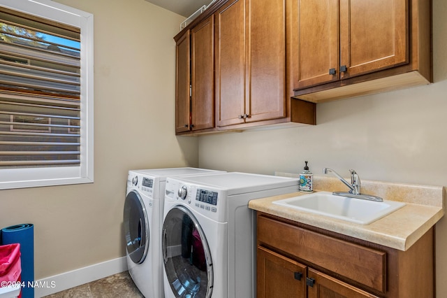 laundry area with sink, cabinets, and washer and clothes dryer